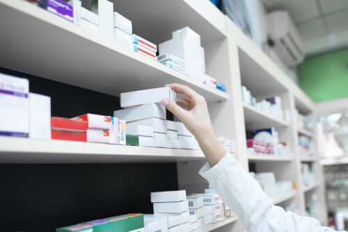 closeup-view-of-pharmacist-hand-taking-medicine-box-from-the-shelf-in-drug-store-scaled.jpg